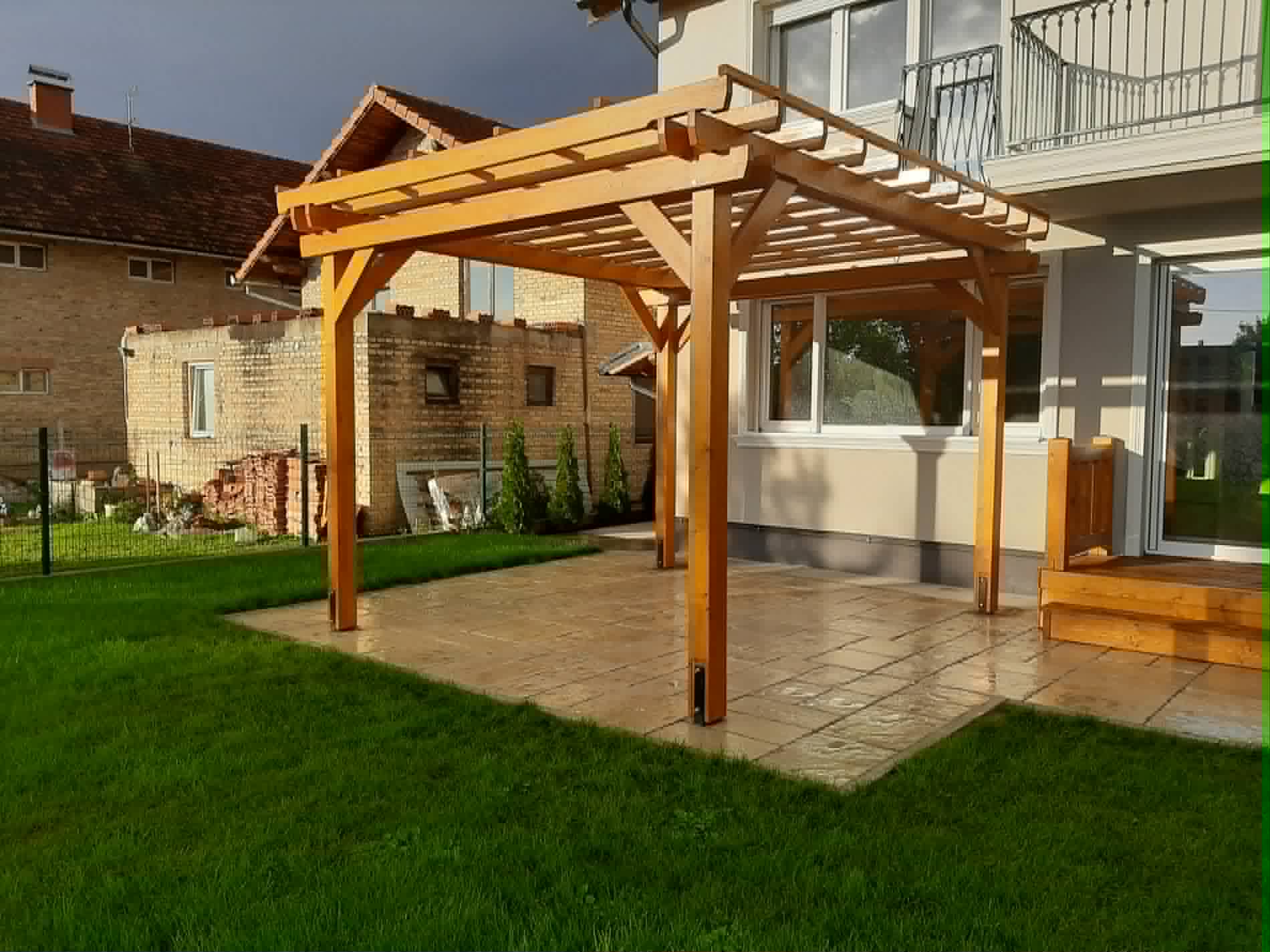 Nyitott lamellás fa pergola térköves terasz fölött